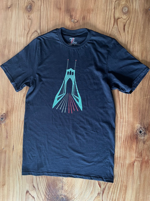 A black cotton short sleeve t-shirt with an elevation of the St. John's bridge, blurred traffic lights and red lights on top of the bridge